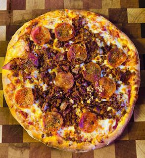 Porky Pig Pizza · Red sauce, local cheese, bacon, pepperoni, chorizo, garlic extra virgin olive oil and herb blend.