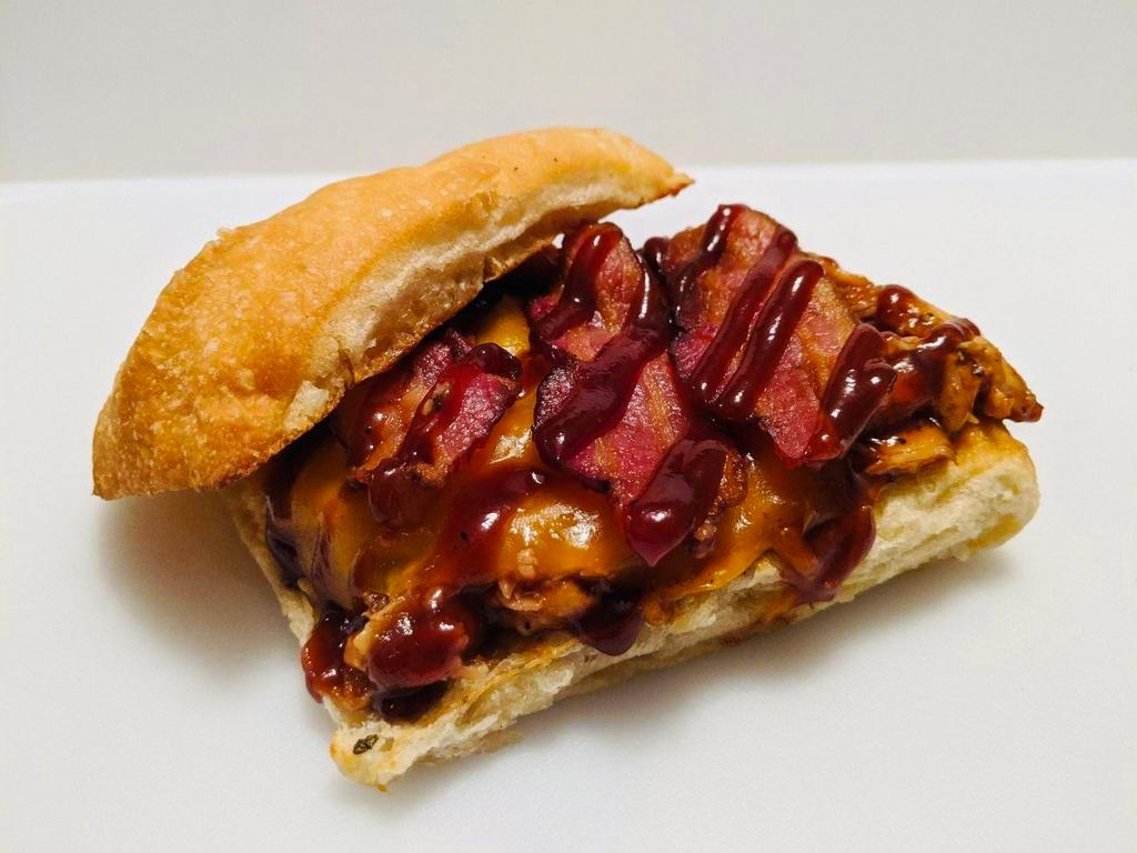 Cowboy Sandwich · Shredded smoked chicken served on a grilled ciabata bun, topped with cheddar cheese, applewood bacon and BBQ sauce.