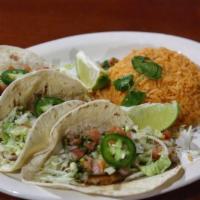 Tacos de Pescado · 3 flour tortillas with grilled tilapia with pico de gallo and lettuce. Served with rice on t...