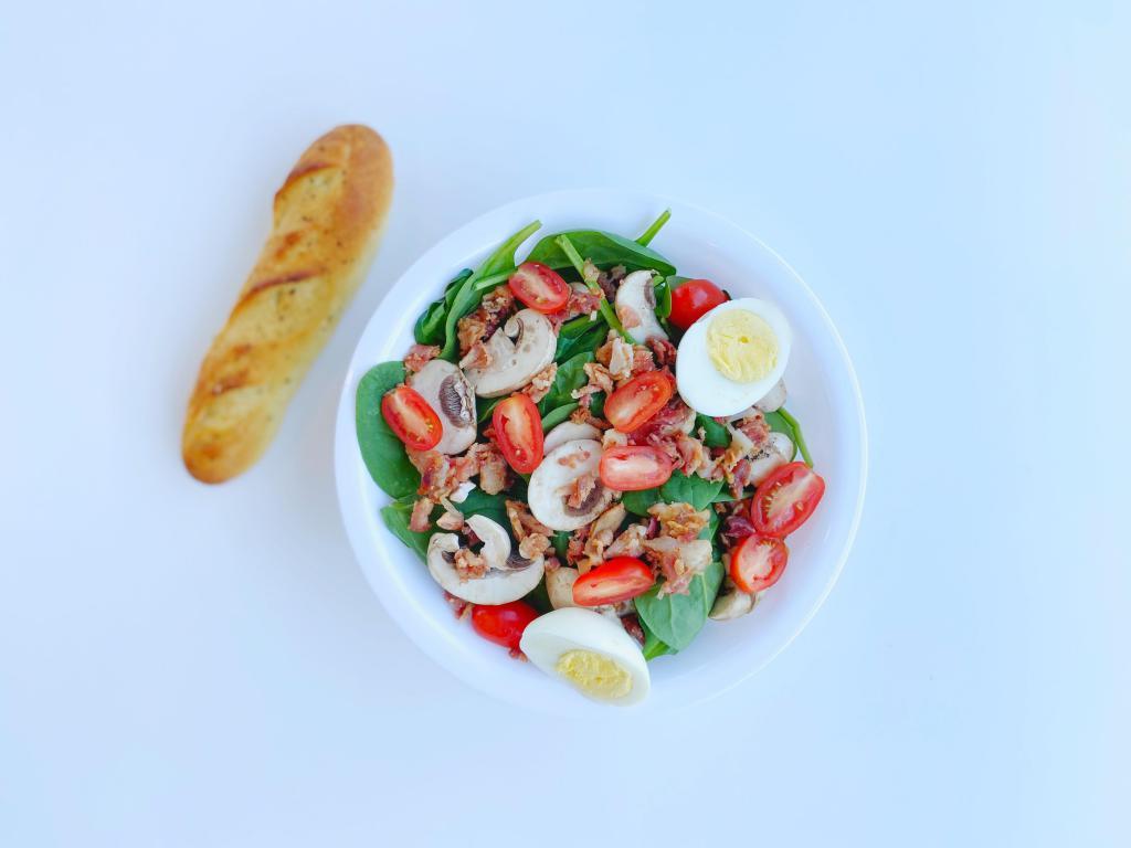 Perfect Spinach Salad · Fresh baby leaf spinach, grape tomatoes, boiled eggs and fresh mushrooms topped with smoked bacon bits.