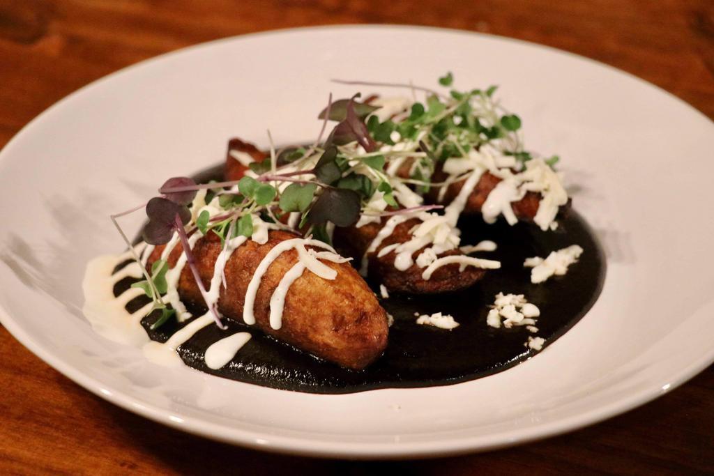 Platanos Fritos con Mole Negro  · 3 fried plantains served over mole negro, topped with cheese and sour cream.