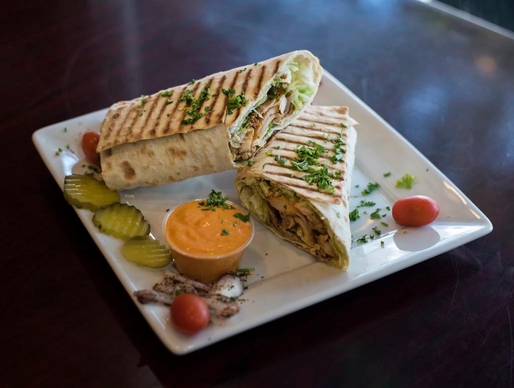 Chicken Shawarma Wrap · Marinated chicken breast thinly sliced, hummus, lettuce, tahini sauce and salad.