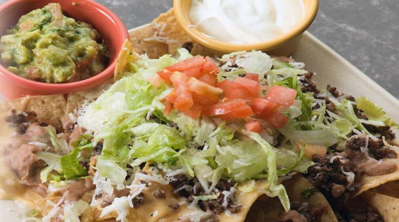 Nachos Locos a la Carte · Ground beef. Served with melted cheese, chips beans, lettuce and tomato.
