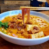 Khao Soi Tofu · Northern style yellow curry noodle soup with tofu, crispy soy protein and lotus root. Vegan. 
