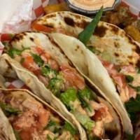 Street Tacos · 3 pieces. Flour tortillas stuffed with grilled chicken, lettuce, tomato, and topped with Z-s...