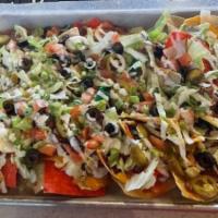 Loaded Nachos · A generous portion of homemade tortilla chips loaded with chili, nacho cheese sauce, topped ...