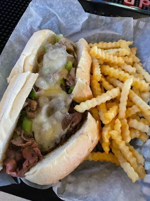 Philly Cheesesteak Sandwich · Roast beef with melted provolone, garlic, sautéed onions and green pepper served on a hoagie roll. Served with chips or seasoned fries.