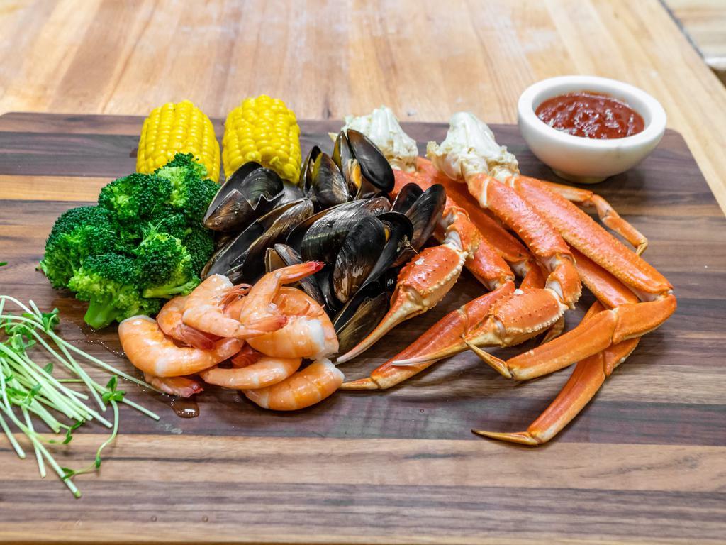 # 63 Snow Crab Leg Platter (Large) · Two snow clusters, 14 large steamed shrimp, 14 mussels, 14 crawfish in garlic-butter sauce, Old Bay, corn on the cob, broccoli.