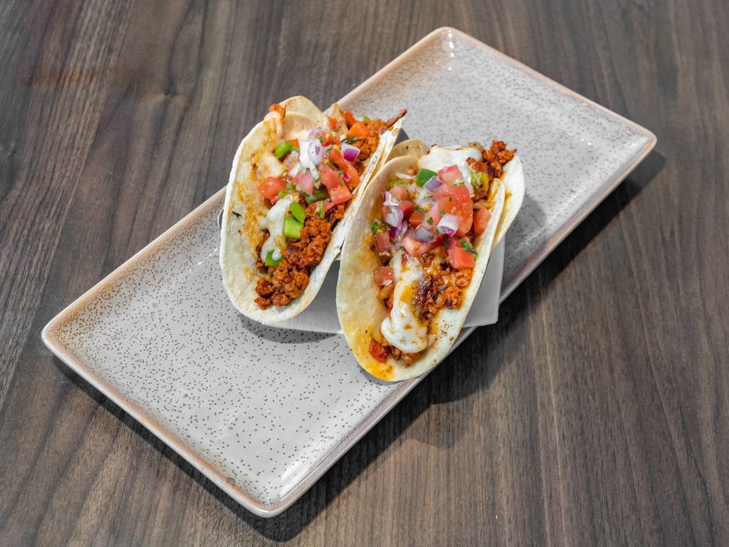 Vegan Tacos · Choice of vegan chicken strips or vegan chorizo, grilled peppers and onions, cilantro, lime and vegan cheese on white corn tortillas.  Gluten free.