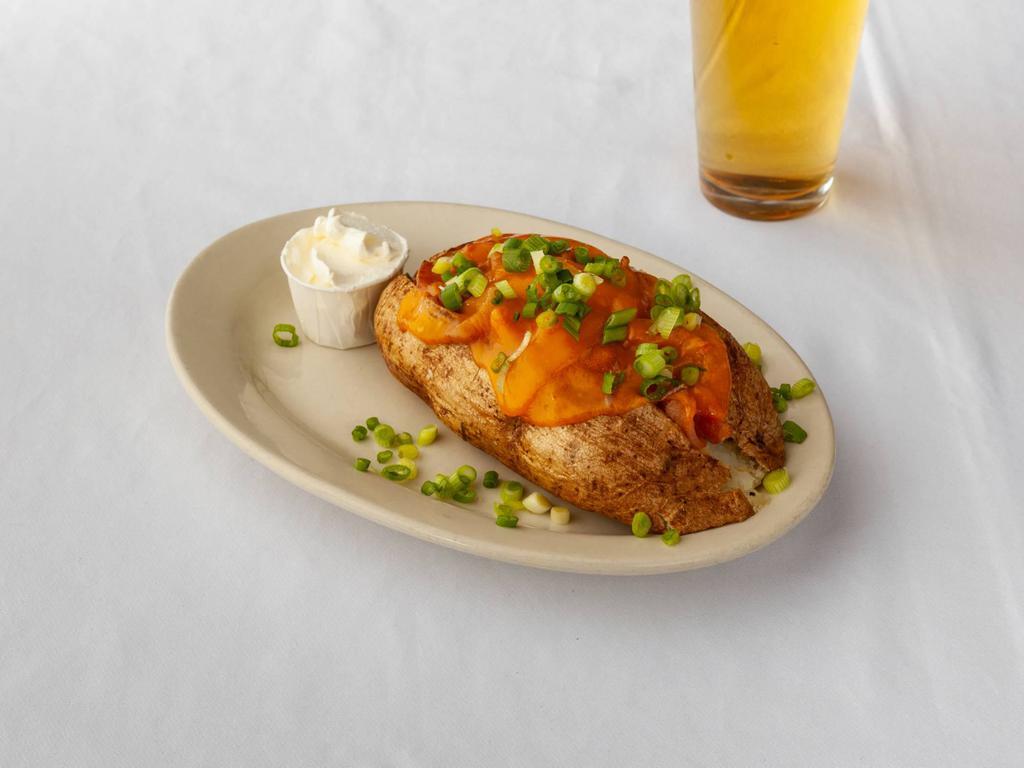 The Classic Spud · Bacon, cheddar and green onion. Giant Idaho potatoes that are baked, buttered, seasoned and topped with fresh ingredients. Served with sour cream. 