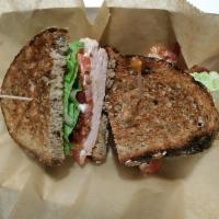 The Club Station Standard · Turkey or ham, lettuce, tomato, bacon, and mayo served on seven-grain.