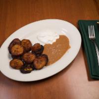 Platano Frito con Cream Y Frijoles · Fried plantain served with refried beans and sour cream.