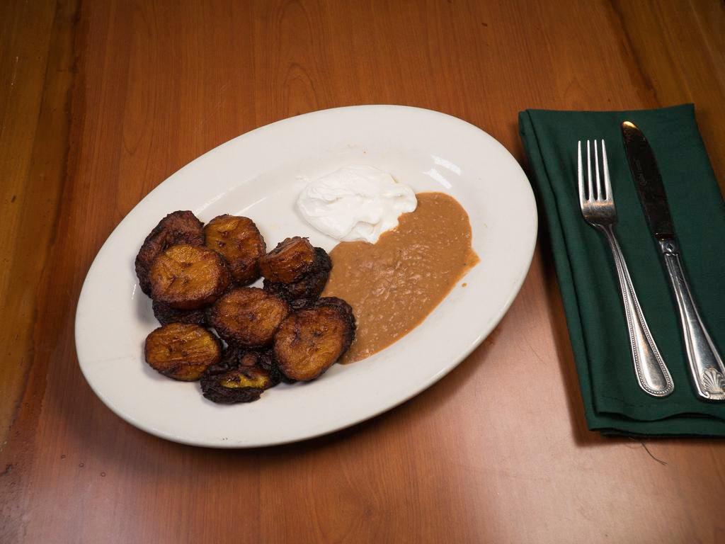 Platano Frito con Cream Y Frijoles · Fried plantain served with refried beans and sour cream.