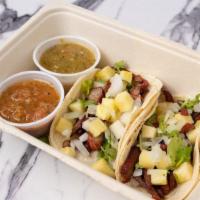 Al Pastor · Shredded pork with chile spiced pineapple, cilantro, onion and lime.  And served in corn tor...