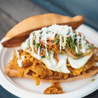 Tecolote (Vegetarian) · Chilaquiles torta with 2 fried eggs on top, carrots, cabbage, onions, sour cream, avocado pu...