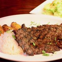 Asado Puertoriqueno · Grilled marinated flank steak with fresh rosemary, garlic, cilantro and olive oil. Served wi...