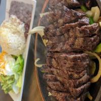 Steak Fajita · Served over a bed of grilled onions and peppers, with a side order of flour tortillas, yello...