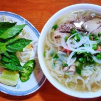 12. Tai and Nam · Beef Pho Noodle Soup topped with Rare steak and flank.