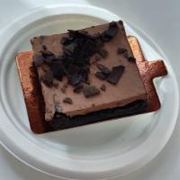 Chocolate Cheesecake Brownie · Our fudgy brownie topped with a layer of chocolate cheesecake and chocolate curls. Gluten Free