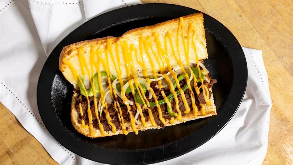 Cheesesteak Grinder · Mozzarella-provolone cheese, Garlic Butter, Steak, Onion, Green Pepper & Topped with Cheese Sauce.