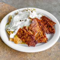 Chilaquiles con Carne · Corn tortillas cooked in green or red sauce topped with onions, cheese and meat.