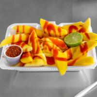 Yummy Mango · Fresh mango slices, chamoy, lime, salt, and tajin. On large plate.