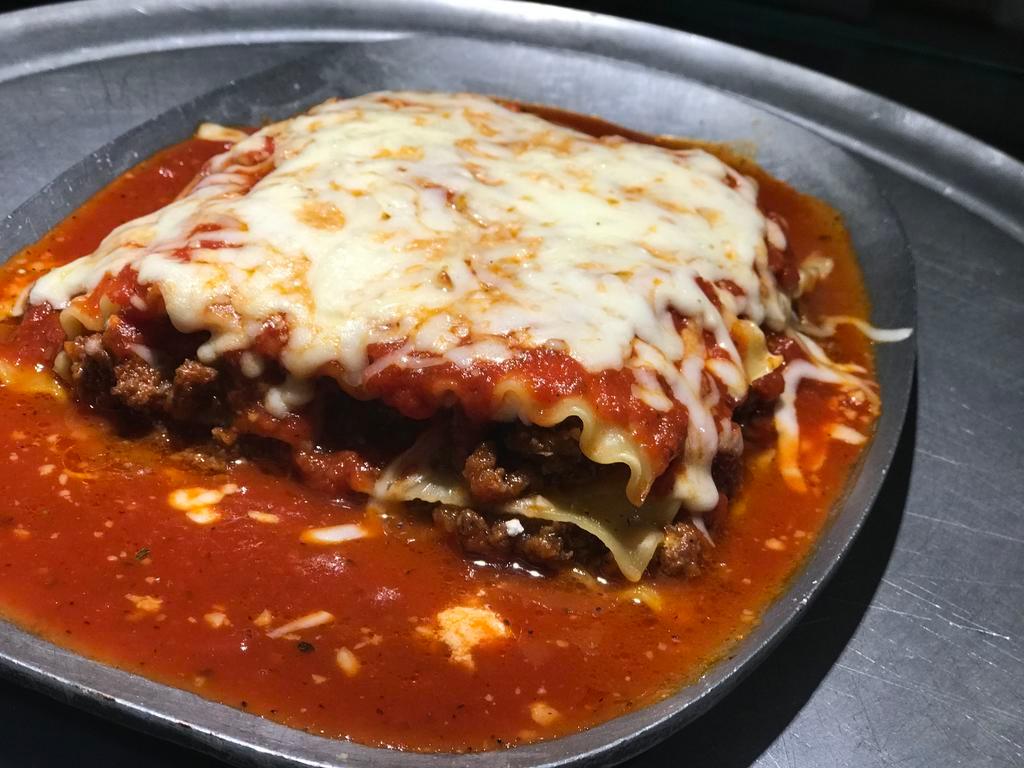 Homemade Baked Lasagna · Layers of lasagana pasta, fresh homemade meat sauce, ricotta cheese and parmesan topped with melted mozzarella. 