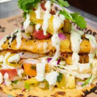 Cabo Fish Taco · Grilled flaky white fish, Cali coleslaw, tropical pineapple salsa and avocado crema. Served ...