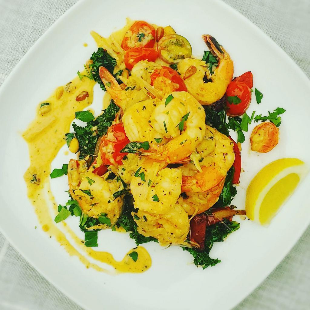 Prawn Scampi  · Wild caught prawns, chopped garlic, shallots, fresh herbs, and cherry tomatoes in a Parmesan cream sauce, served over sautéed kale, onions, and red peppers.