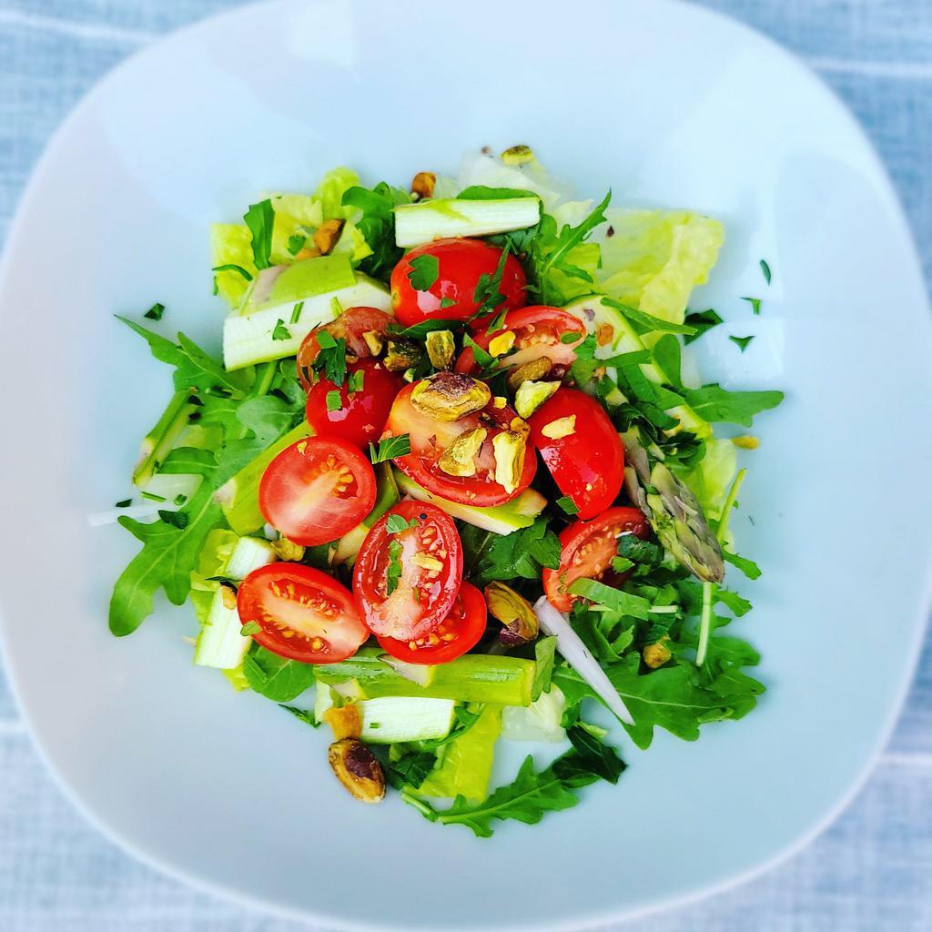 House Salad · Crisp hearts of romaine tossed with wild arugula, fresh basil, chopped asparagus, sliced shallots, ﻿ cherry tomatoes, and toasted pistachios served with a house made champagne vinaigrette on the ﻿side.

