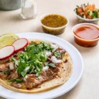 Steak Taco (3 Pieces) · Tacos topped with fresh onions and cilantro, garnish with a lime wedge and radish, accompani...