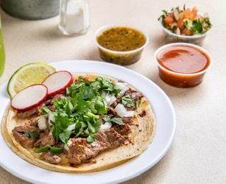 Steak Taco (3 Pieces) · Tacos topped with fresh onions and cilantro, garnish with a lime wedge and radish, accompanied by two of our homemade sauces are salsa verde, salsa raja, and guacamole sauce.