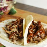 BBQ Pulled Pork Taco · Served with wood-smoked 'pulled' BBQ pork shoulder on tortilla with your choice of onions, p...