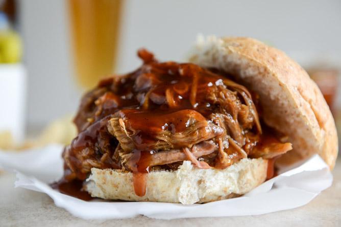 Pulled Pork Sandwich · Wood-smoked pork shoulder, chopped and served on a gourmet bun with your choice of onions, pickles and barbecue sauce.
