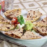 Quesadillas · Grilled, homemade flour tortillas stuffed with chicken, beef, or shrimp fajita and melted Mo...