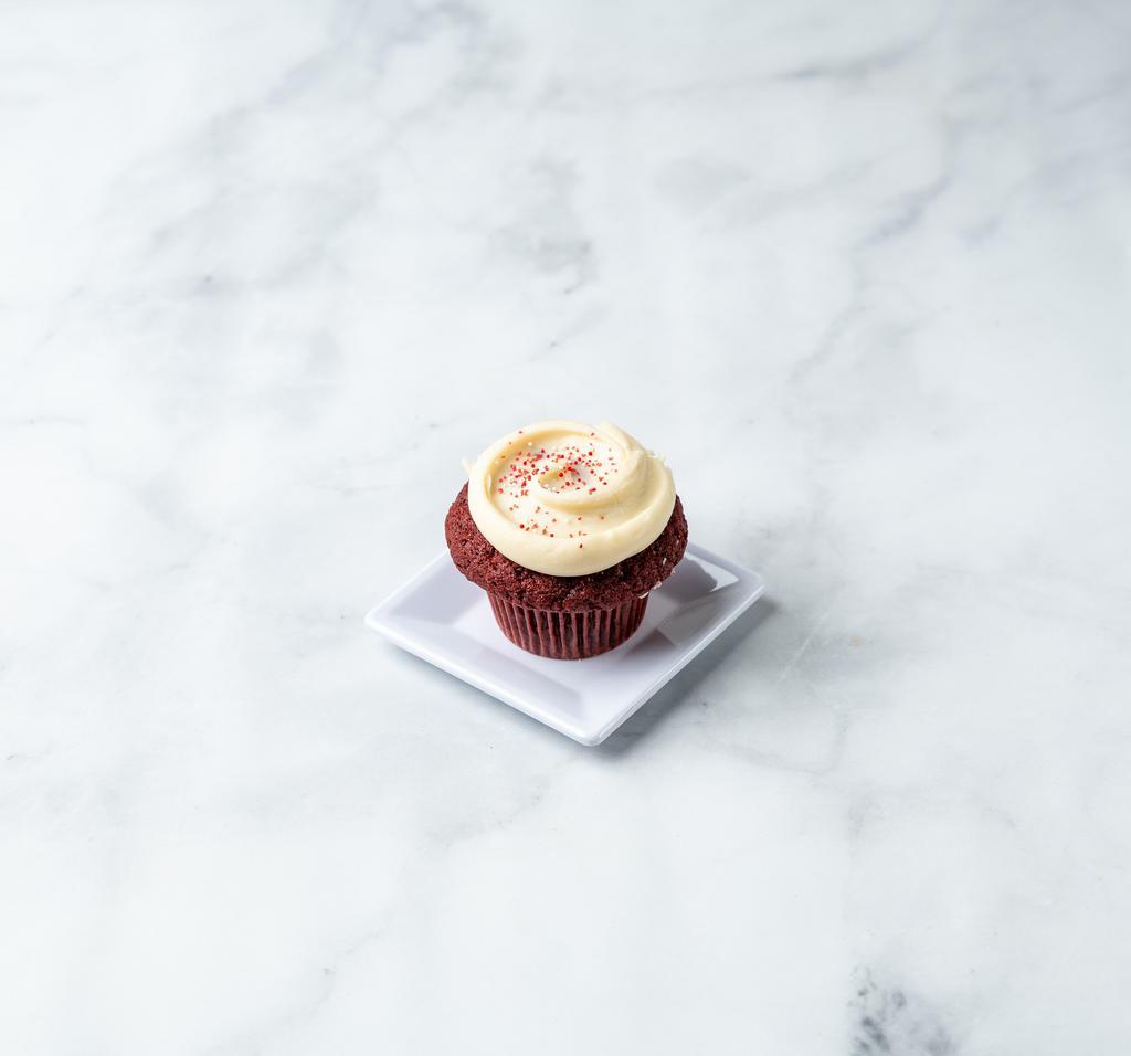 Red Velvet Cupcake · A classic southern buttermilk cake with a hint of cocoa. Topped off with a rich pile of cream cheese frosting and a dusting of red sparkle.