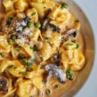 Fioretti alla Boscaiola · Our signature homemade pasta in a tomato cream sauce (porcini mushrooms, green peas, prosciu...