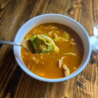 Tortilla Soup · Grilled chicken in a delicious broth with onions, avocado, cheese, and fried tortilla strips.