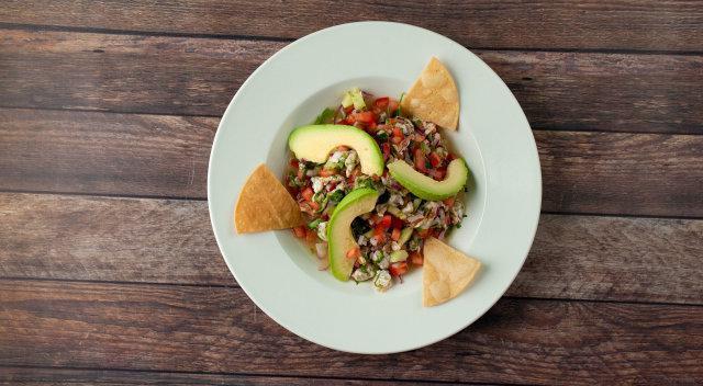 Shrimp Ceviche · Prawns tossed in a lime citrus sauce with avocado, cilantro, tomato, and onions.