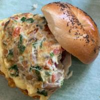Western Omelette Sandwich Breakfast · Ham and egg sandwich with peppers and onions on a roll or bagel