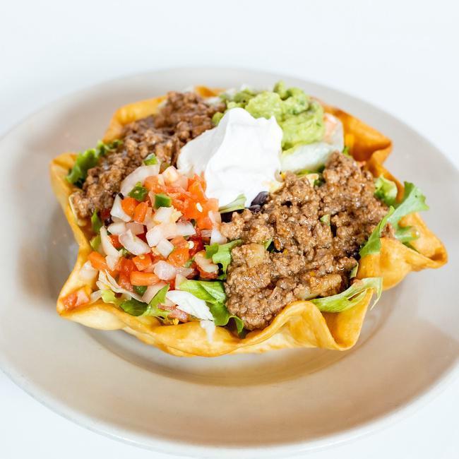 Fiesta Taco Salad · Picadillo beef, refried beans, cheddar cheese, diced tomatoes, sour cream, guacamole & pico de gallo on a bed of mixed greens & a crispy flour tortillas, served with a side of fresh made salsa