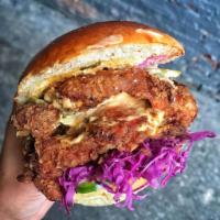 The Rival · Fried spicy chicken with red cabbage slaw, pickles, & house sauce on a brioche bun.  (Warnin...