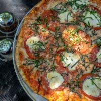Margherita Pizza · Mighty vine tomatoes, fresh mozzarella, basil and garlic.