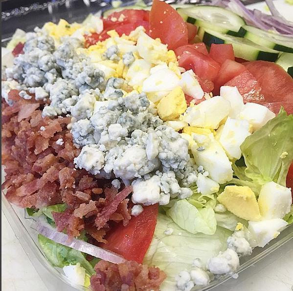 Cobb Salad · Romaine and iceberg mix with boiled eggs, bacon, cucumber, bleu cheese crumbles, tomato, and red onion.