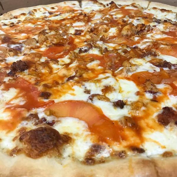 Buffalo Chicken Pizza · Ranch dressing base with mozzarella, sauteed shallots, bacon, tomatoes, and chicken tossed in Buffalo sauce.