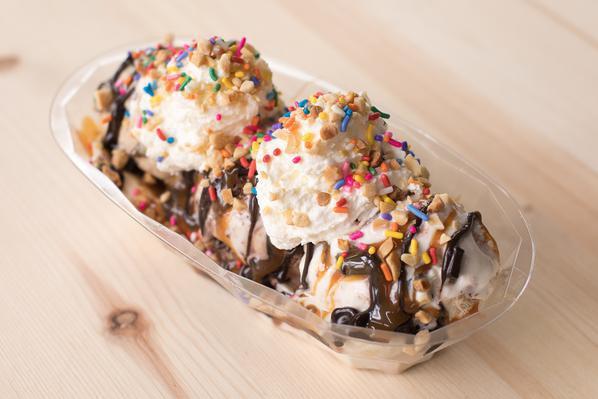 Banana Split · Three scoops of ice cream atop a split banana, hot fudge, caramel, fresh whipped cream, and your choice of two toppings.  It's a boatload!