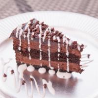 Chocoholics Chocolate Cake · Double layered chocolate cake topped with chocolate chips, white and dark chocolate sauce.