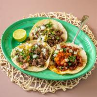 Carne Asada Taco · Beef steak meat served on two corn tortillas with onions cilantro and green salsa on top