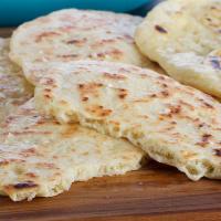 Spiced Paneer Naan · Spiced grated paneer stuffed in naan and baked in the clay oven.