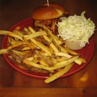 The Pulled Pig Sandwich · Slow smoked pulled pork with BBQ sauce and coleslaw on a grilled brioche bun.